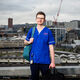 Elliot wearing blue scrubs, Sheffield skyline in background