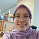 Anis Apriliawati in glasses and headscarf smiling at the camera