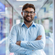 Sajid Bashir wearing a light blue short with his arms folded.