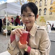 Penelope Gia Bao Huu Nguyen in a pretty town with a drink