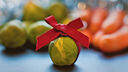 Picture of a brussels sprout with a red bow tied around it