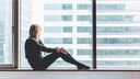 Woman sitting looking out window by herself
