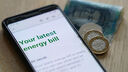 a phone screen shows an energy bill