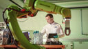 A engineer at the University of Sheffield AMRC stood next to a robotic arm