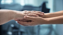 Photo of a young and older person's arms stretched out to lay the older person's arms across the younger arms.