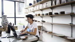 Small business owner using computer inside store