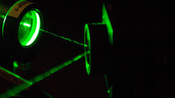 A green laser shining through a lens