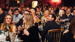 image of people sat at tables at awards ceremony 