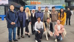 A group smiling outside of a building
