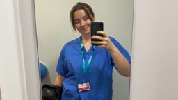 Biosciences graduate Tegan Fitch dressed for her placement in blue scrubs