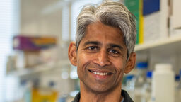 A man smiling at the camera with his arms crossed.